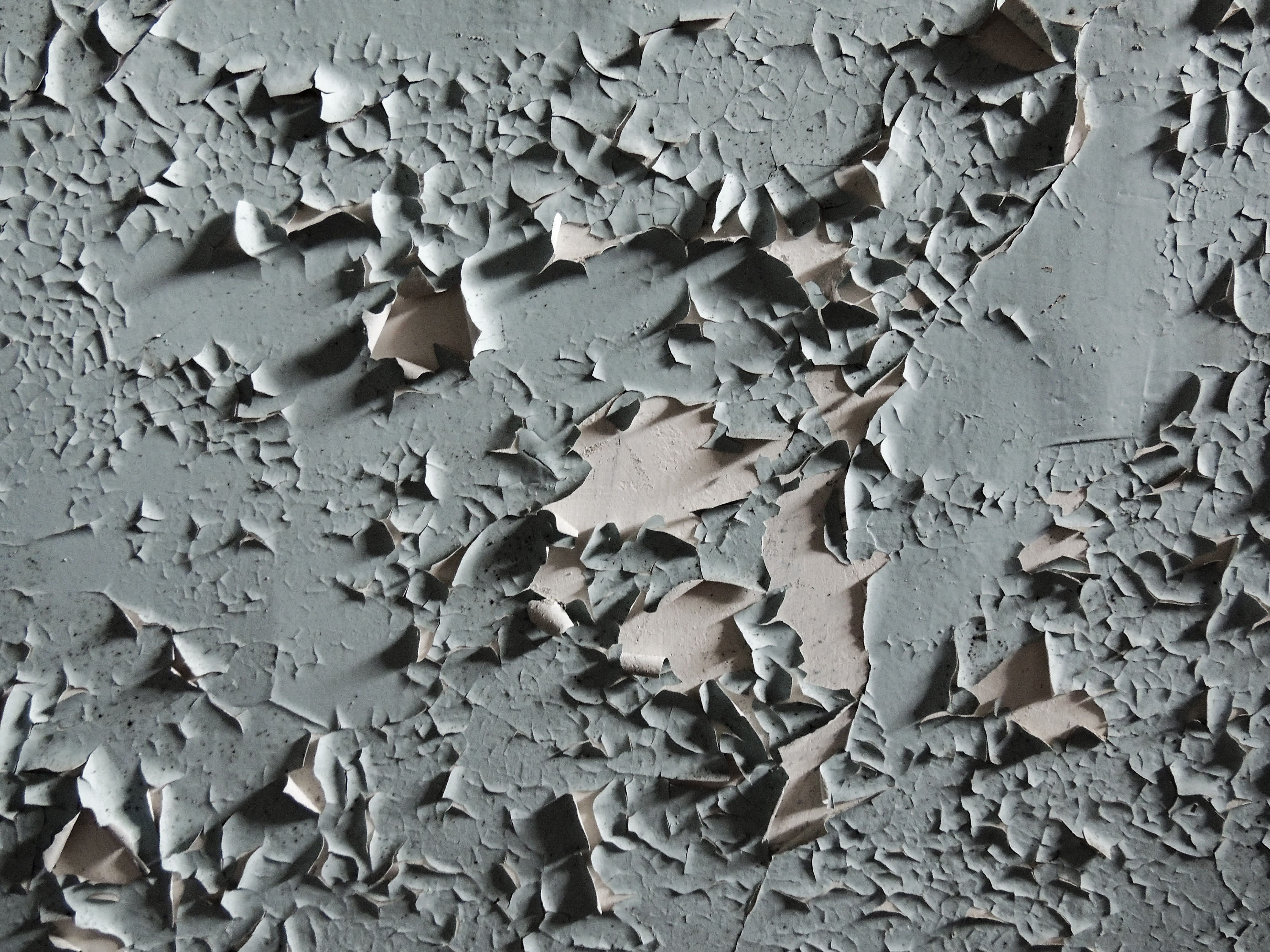 Gros plan sur une ancienne peinture murale craquelée et écaillée