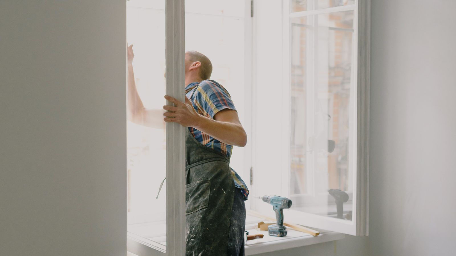 Artisan installant une nouvelle fenêtre dans un logement en rénovation
