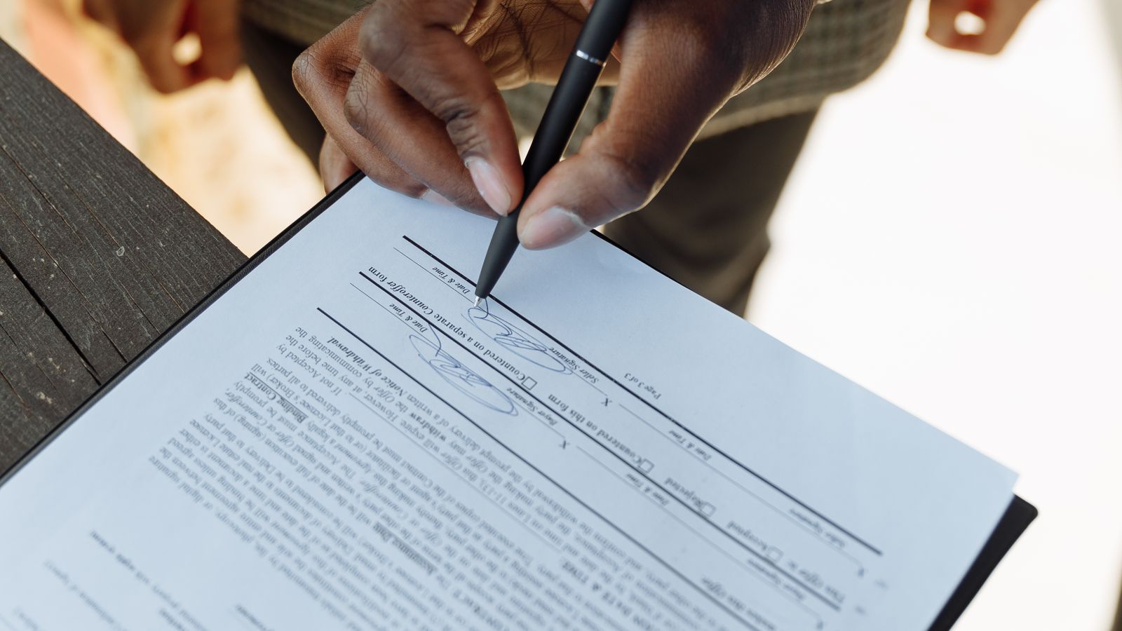 Personne signant un contrat de location sur une table