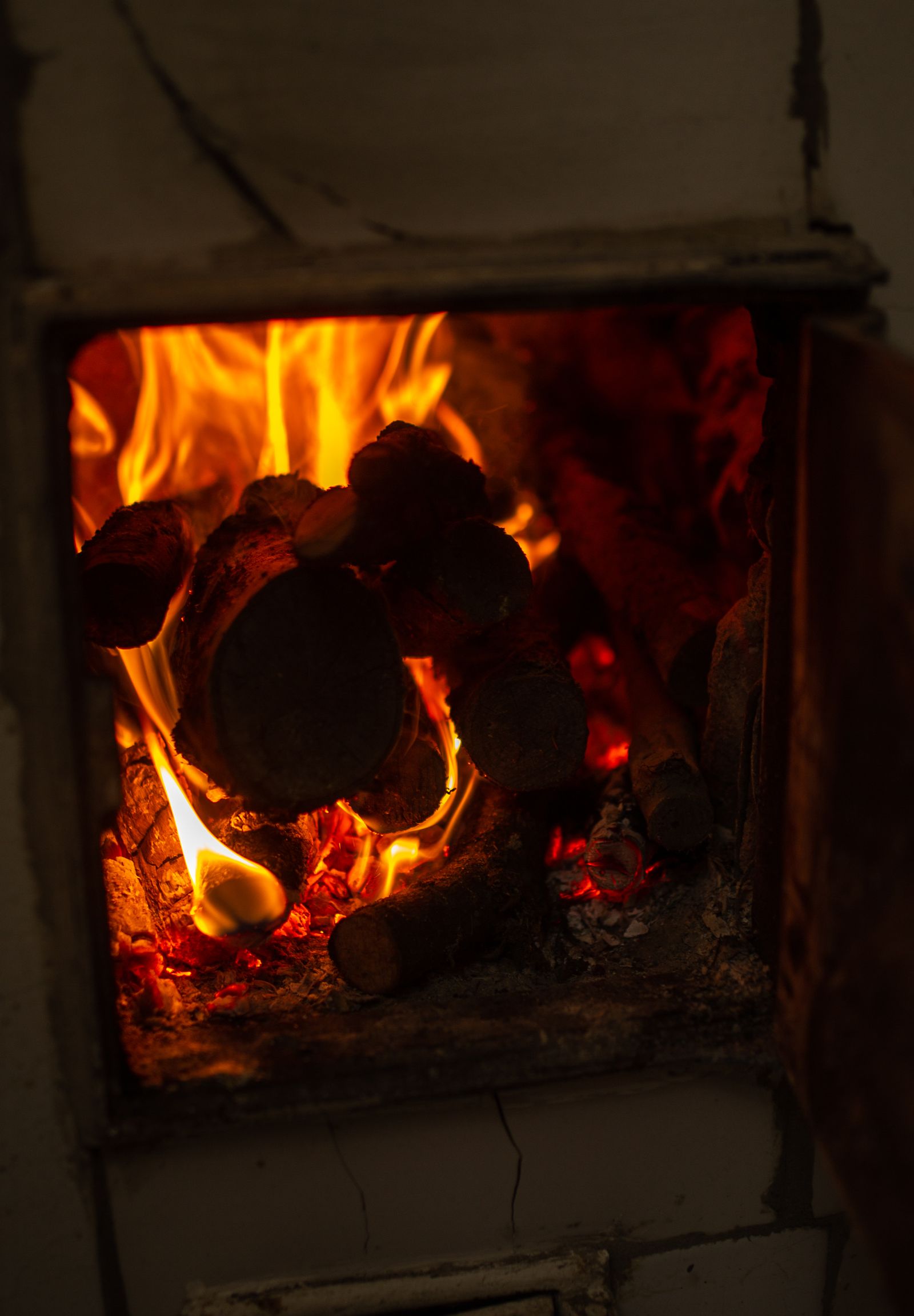 Feu de bois allumé dans un poêle de masse en maçonnerie
