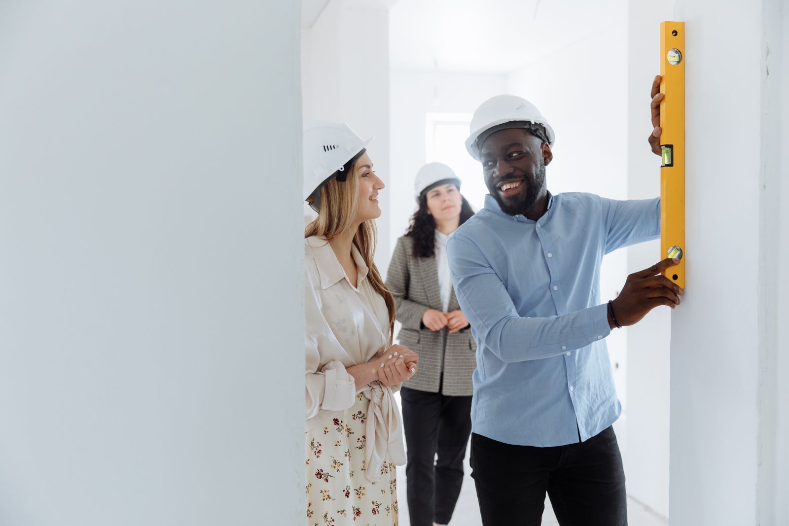 Professionnels inspectant et mesurant un mur intérieur avant une transaction