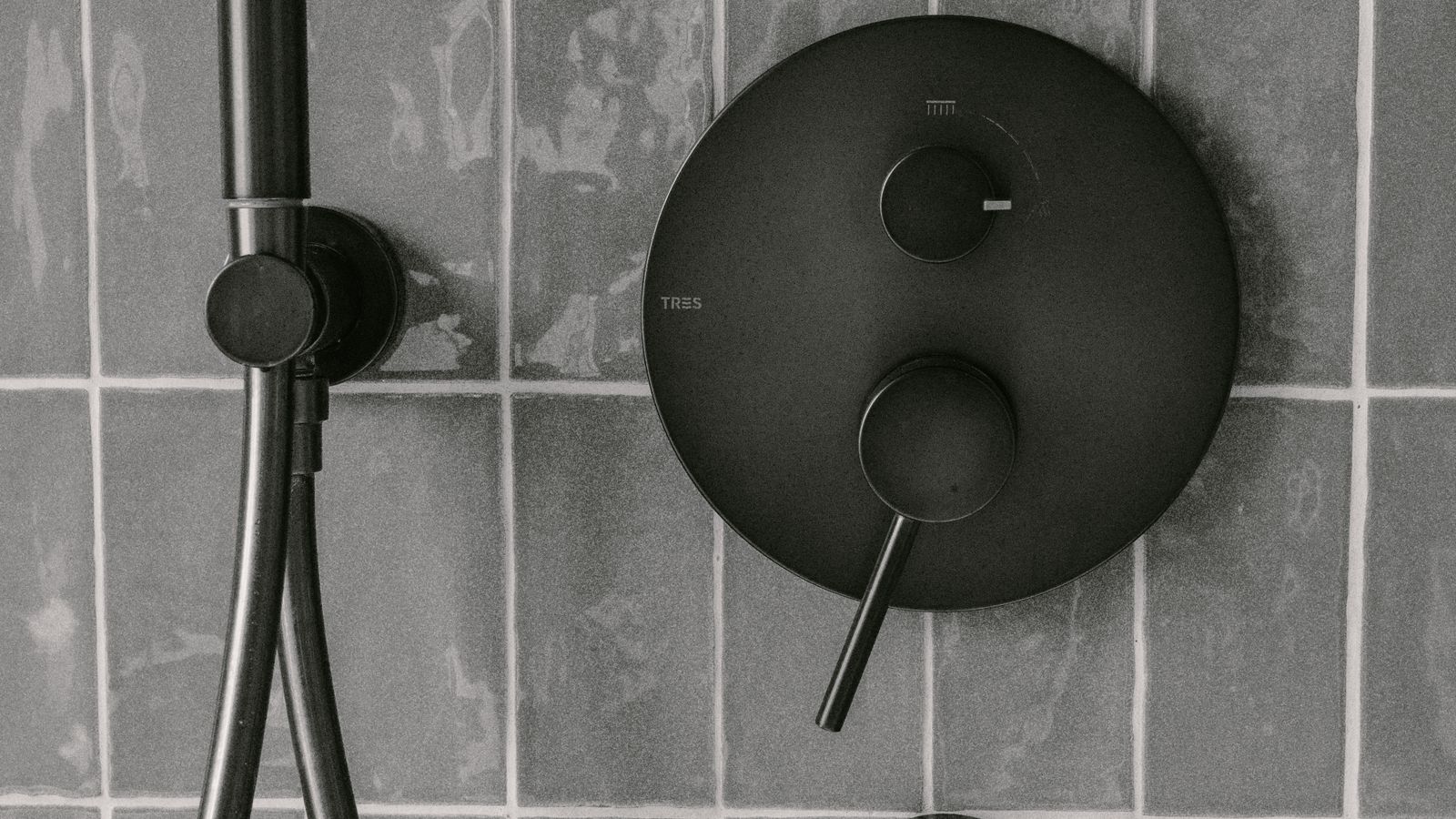 Douche moderne avec robinetterie noire sur un mur carrelé