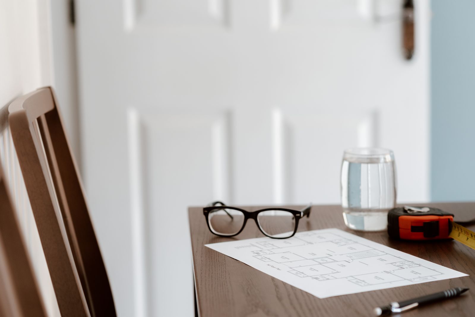 Documents de logement, mètre ruban et stylo posés sur une table