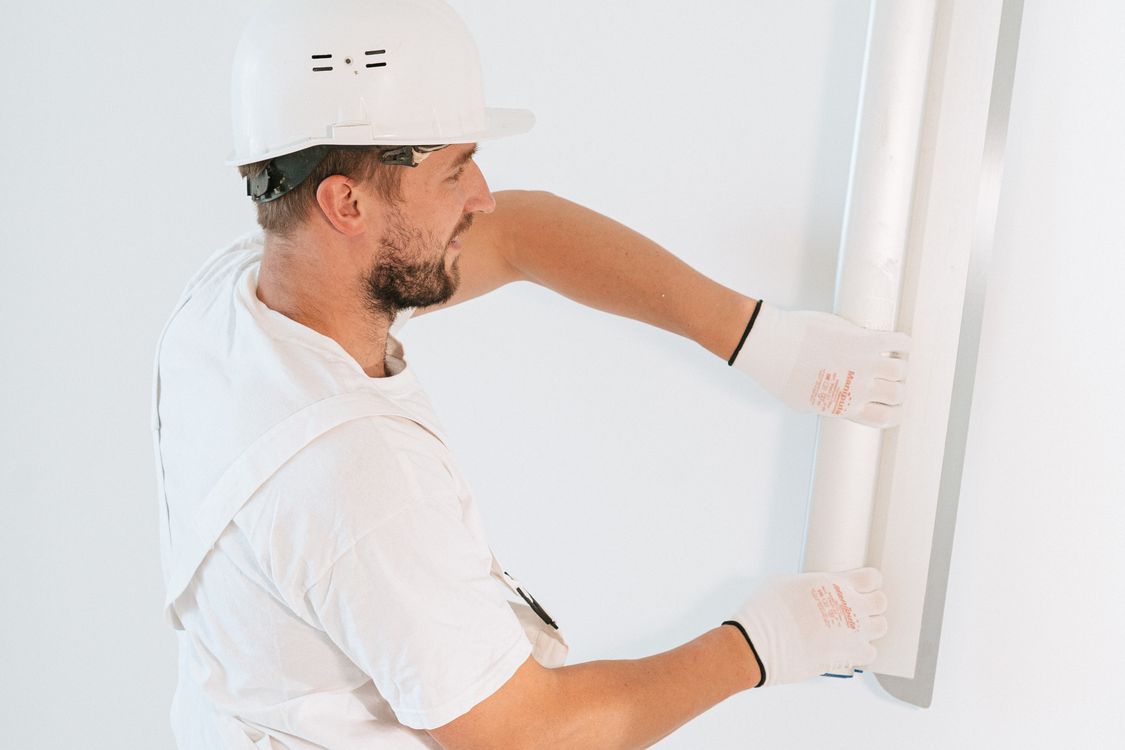 Professionnel intervenant sur une paroi intérieure en rénovation