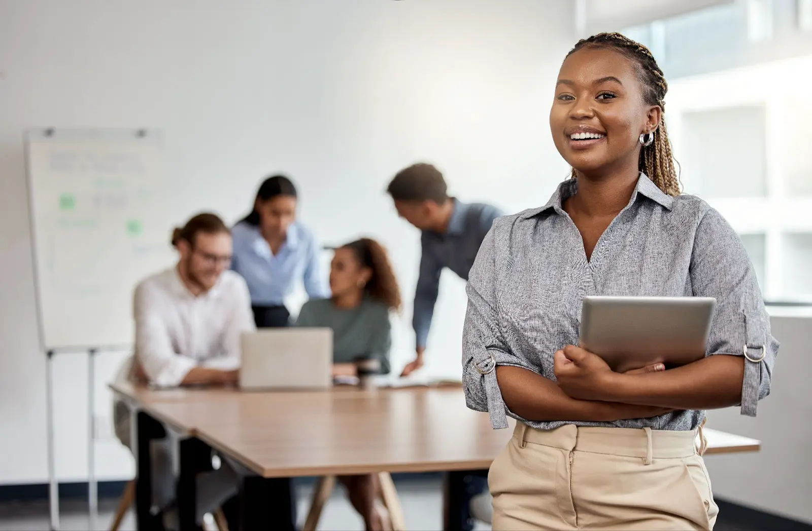 A teacher standing in a classroom with other teachers in the background