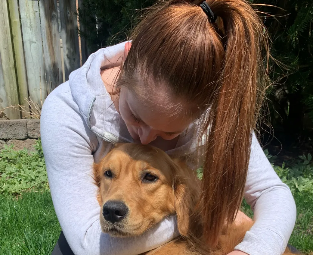 Sage the dog getting hugged by their mom.