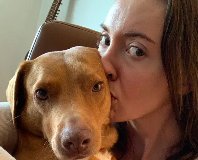 Kali the dog getting a kiss from his mom.