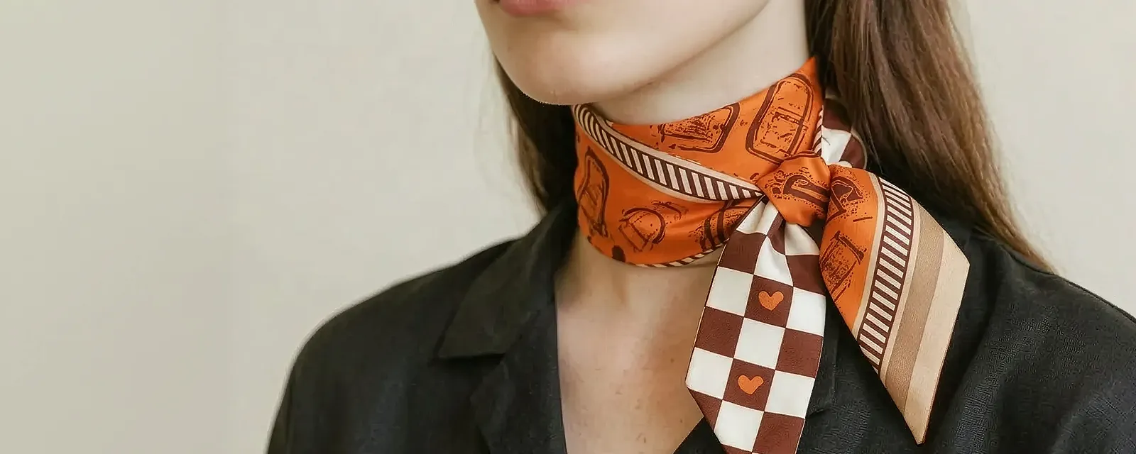 The silk scarf that Fetch Pet Insurance is gifting benefactors is shown on a model and on a handbag.