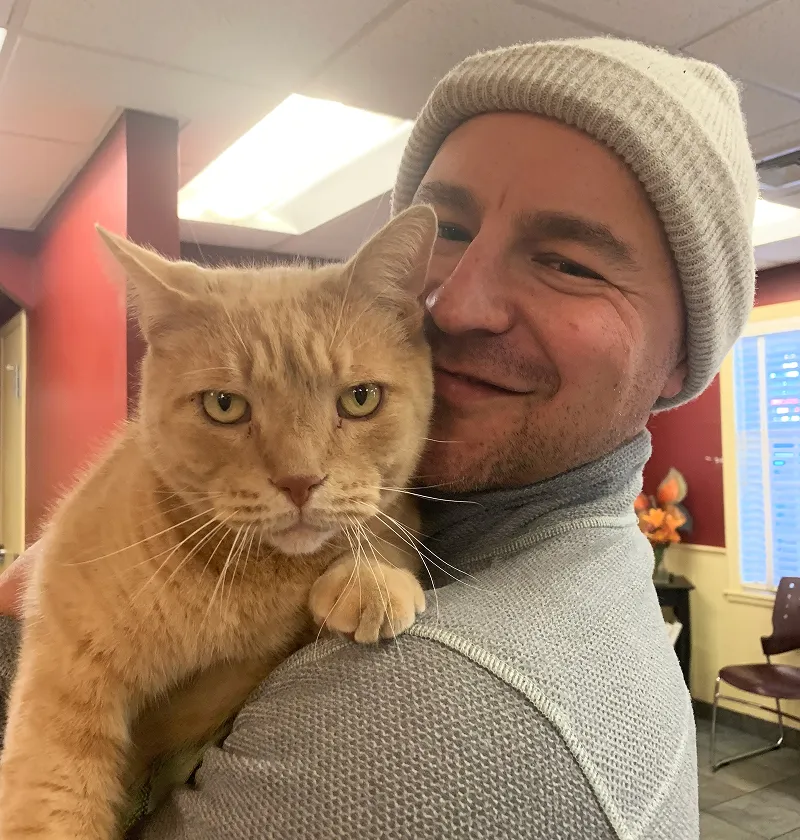 Theodore the cat being held by dad.