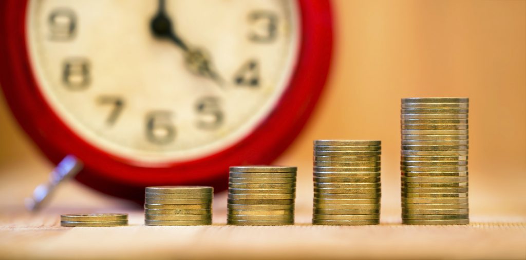 An imahe showing a clock behind coins.