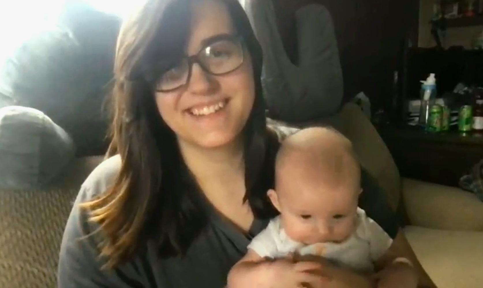 A woman hugging a man holding a baby.
