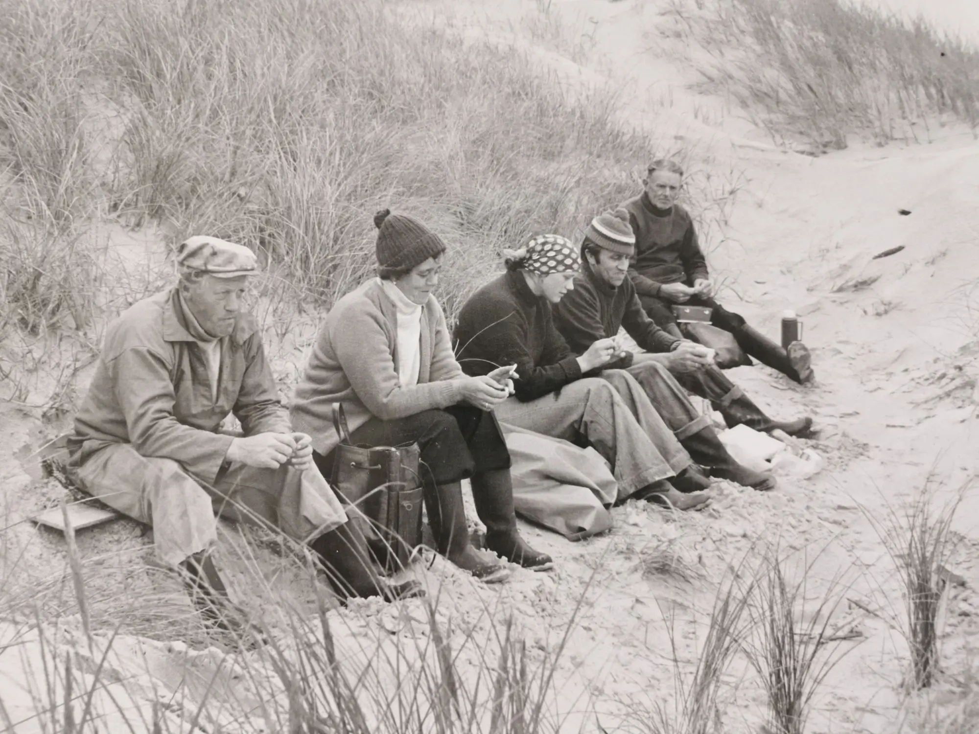 5 people sitting on the beach