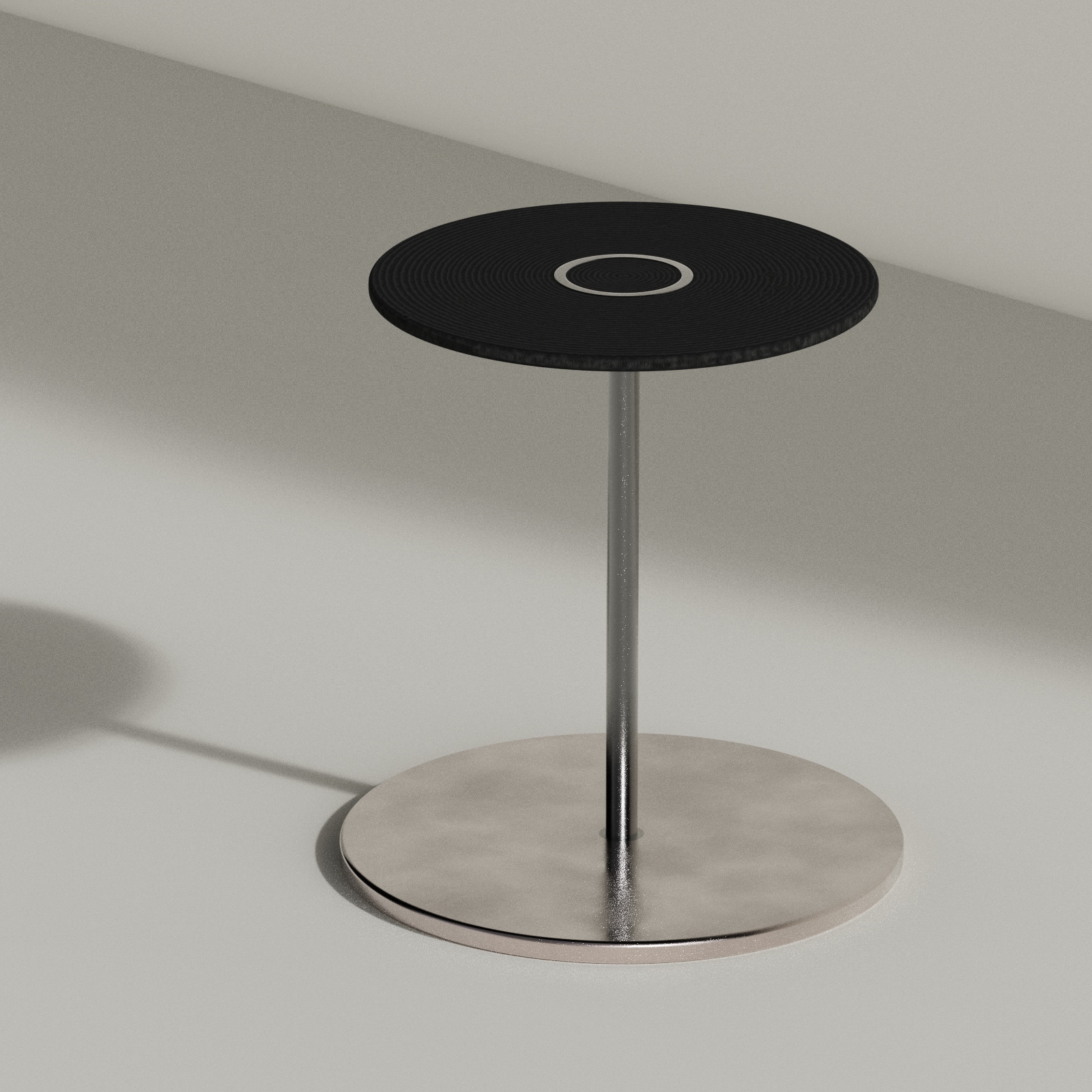Modern round side table with a black textured top and a metallic base and pedestal.
