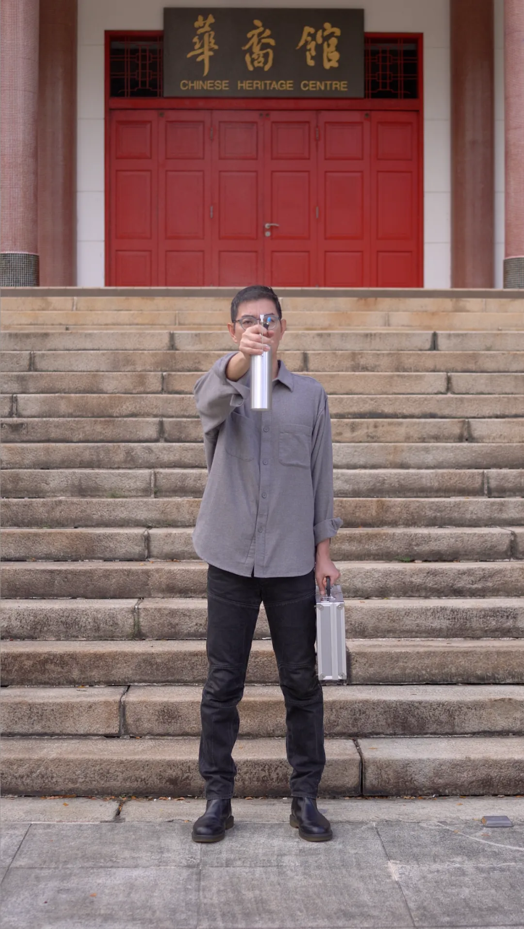 Still from I Want to Infect You with History: the artist on the steps of the Chinese Heritage Centre