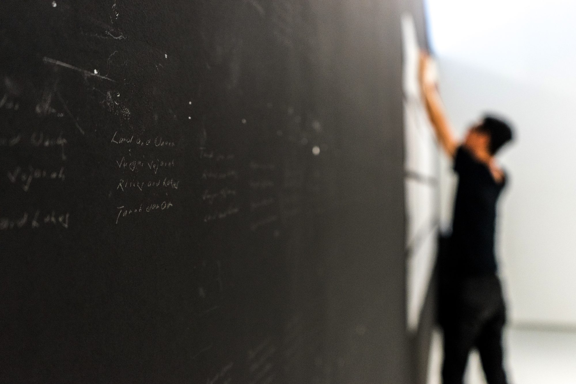 Handwritten lines appearing on the black wall
