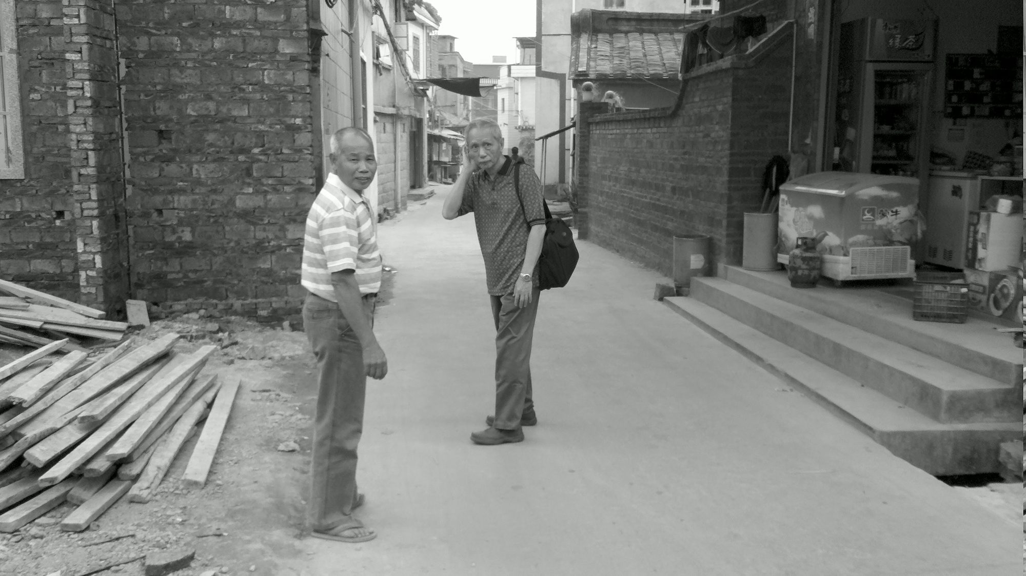 Two men standing in a village lane