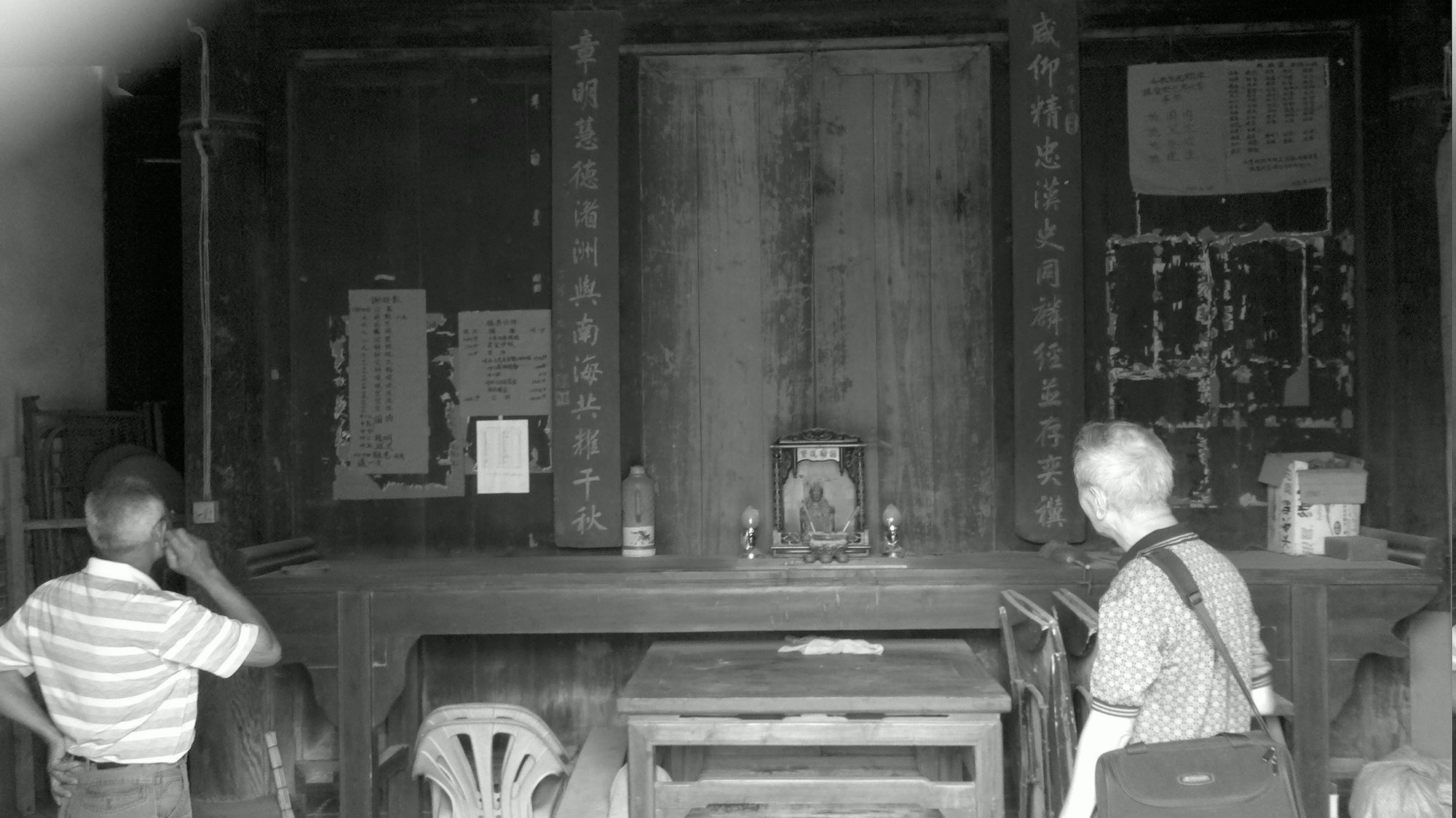 Two men looking at an ancestral altar