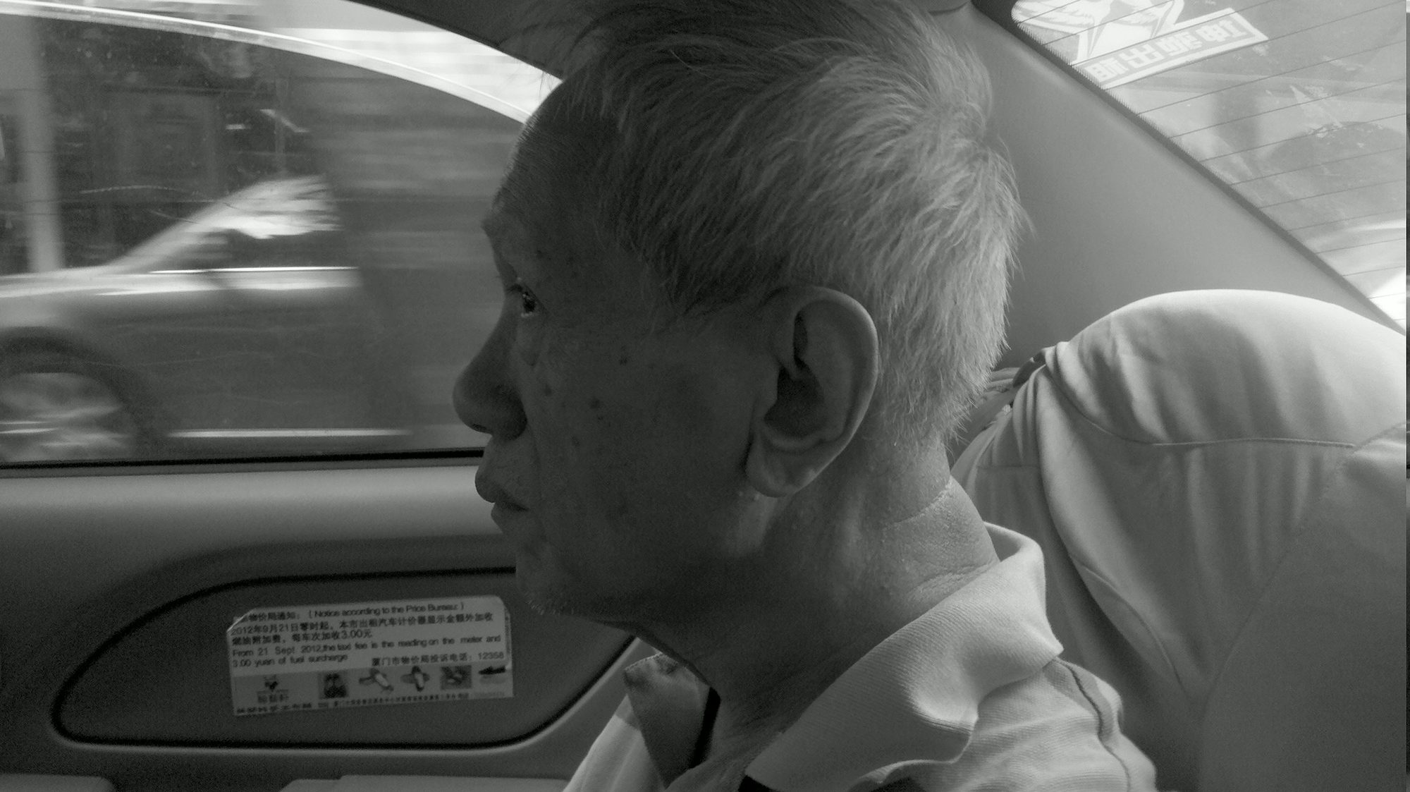 An older man looking out from a car