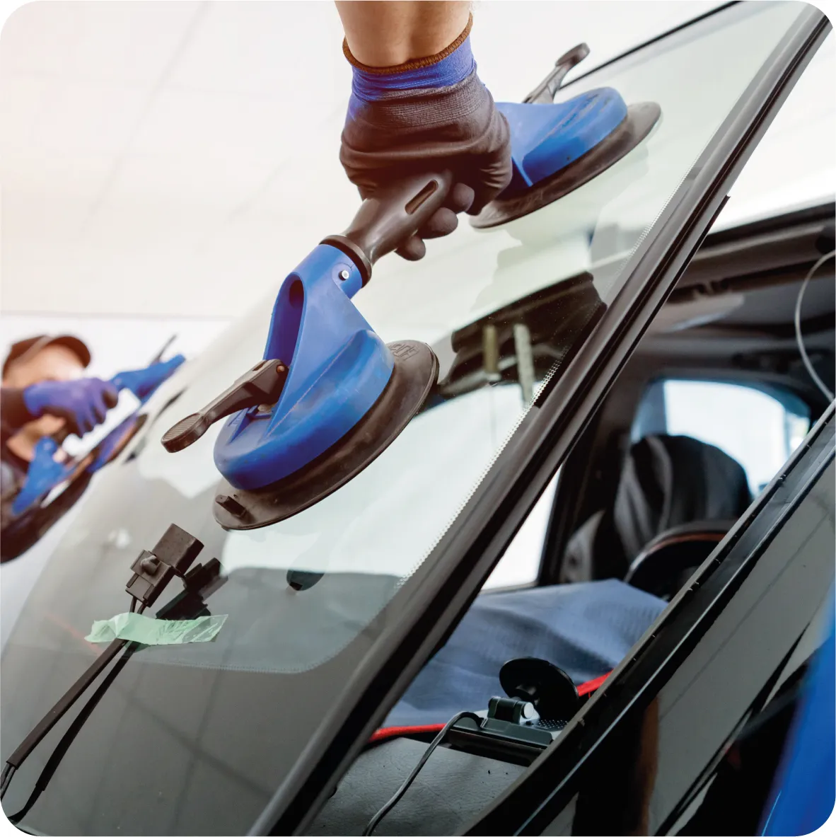 technicien effectuant le remplacement d'un pare-brise