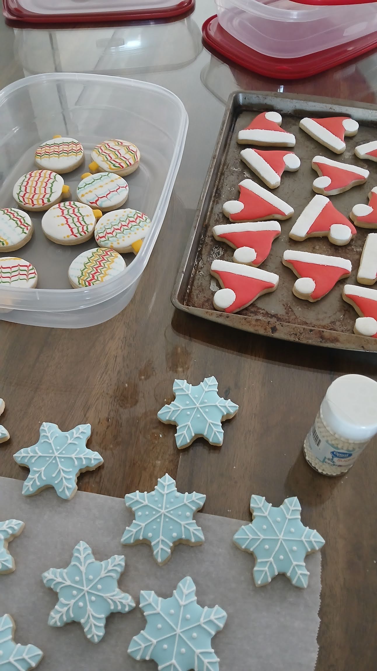 Christmas sugar cookies in various stages of decoration with royal icing