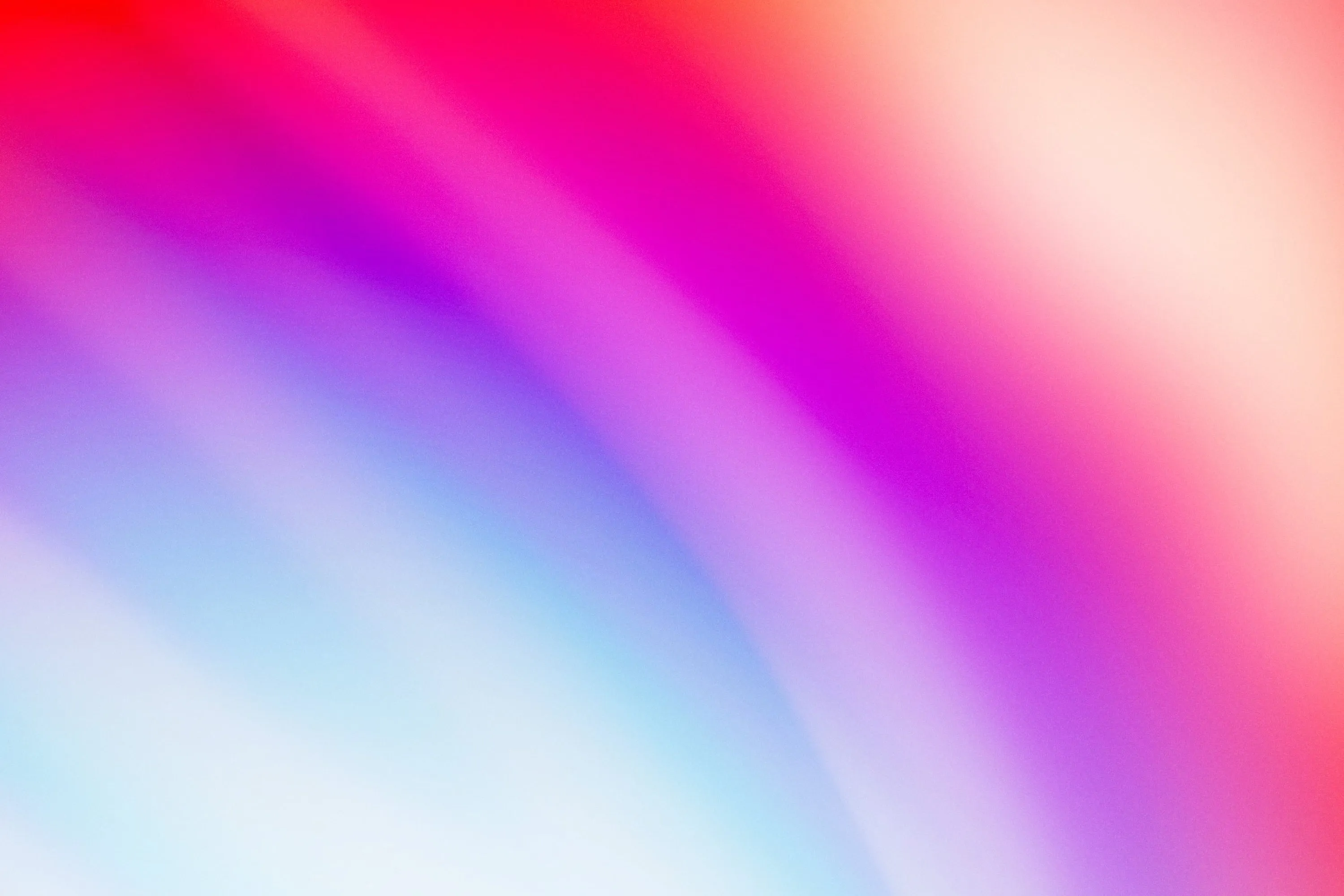 Abstract gradient of blended vibrant colors including red, pink, purple, and blue.