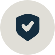 Dark shield icon with a white checkmark inside on a light beige circular background.