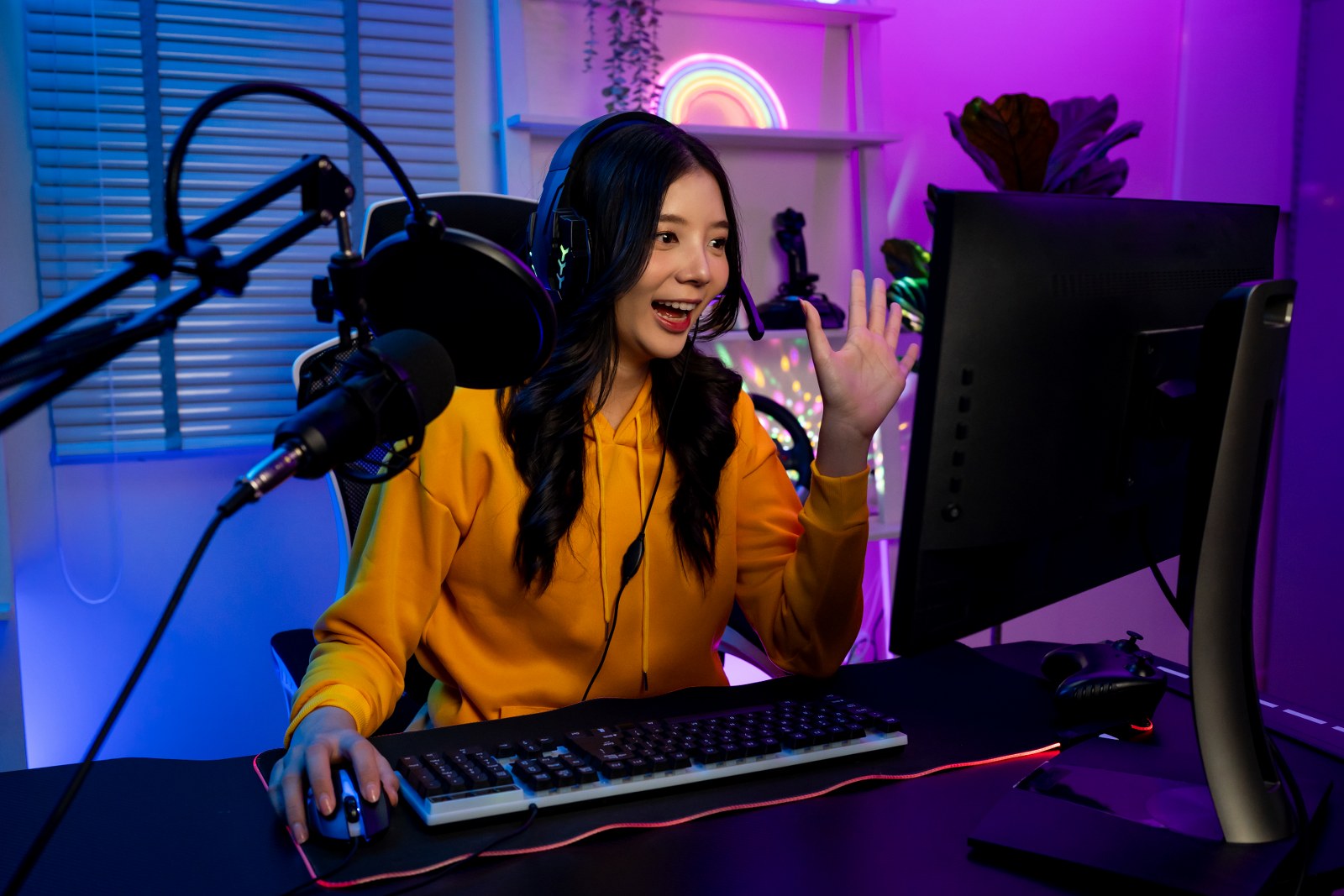 A successful Twitch streamer waving at her audience.