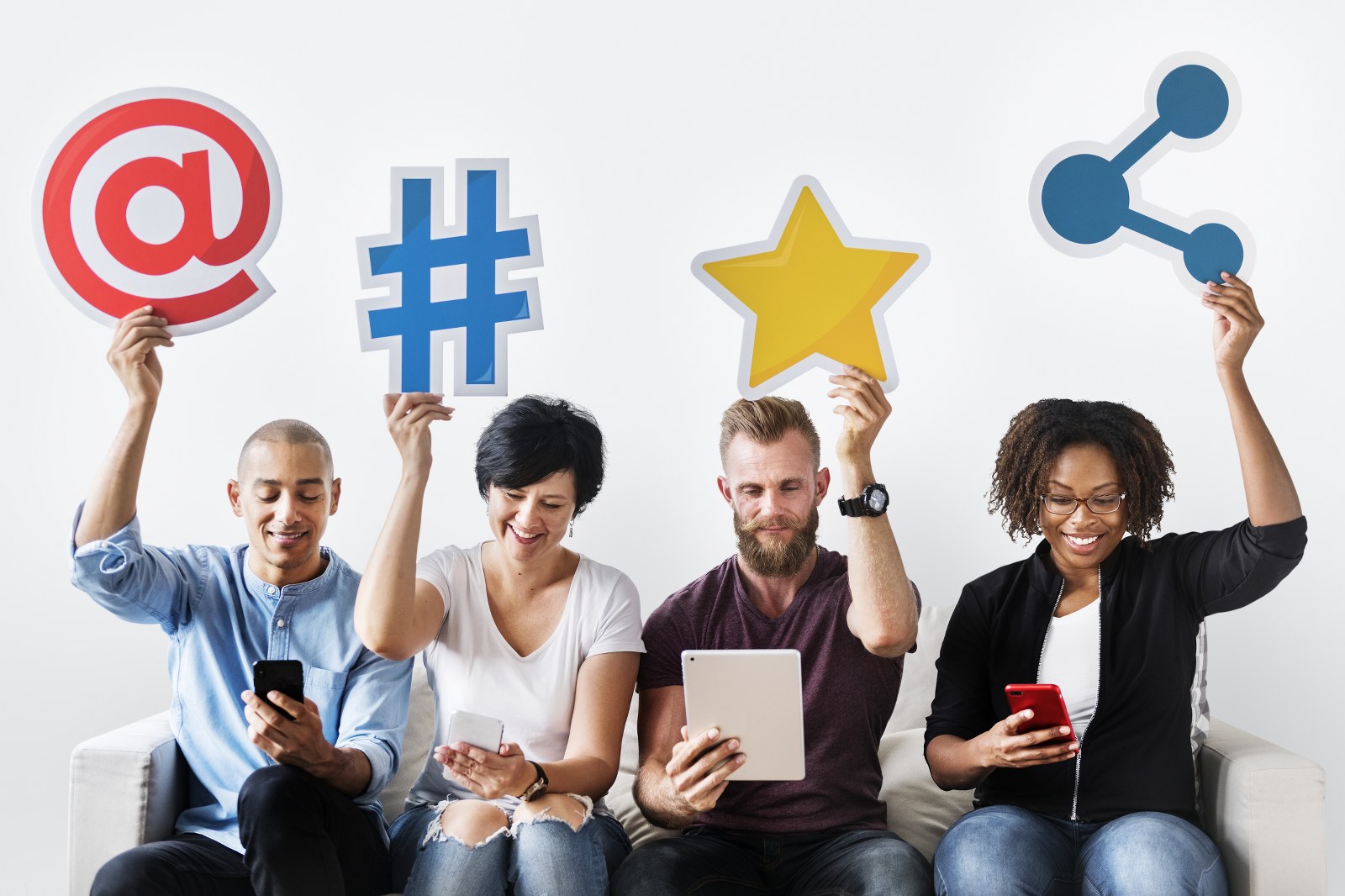 Four people using different social media platforms on handheld devices.