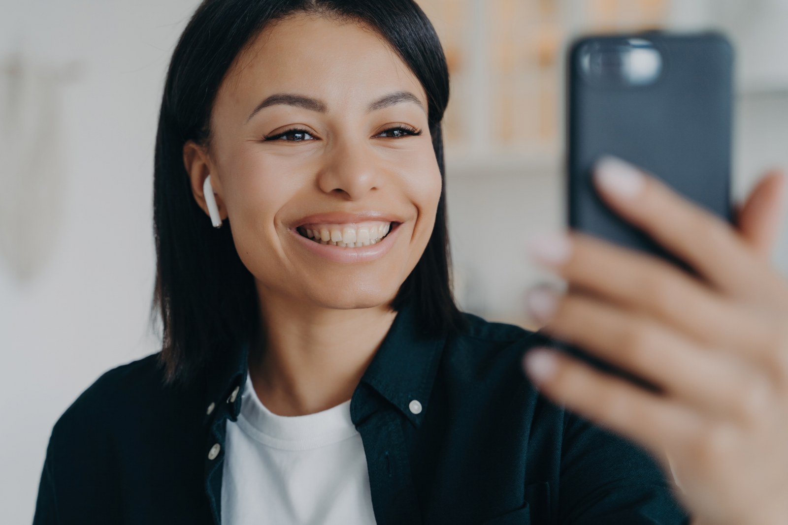 A woman smiling while using her phone.