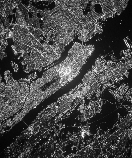 Satellite view of a city at night, representing the digital network for tokenized assets.