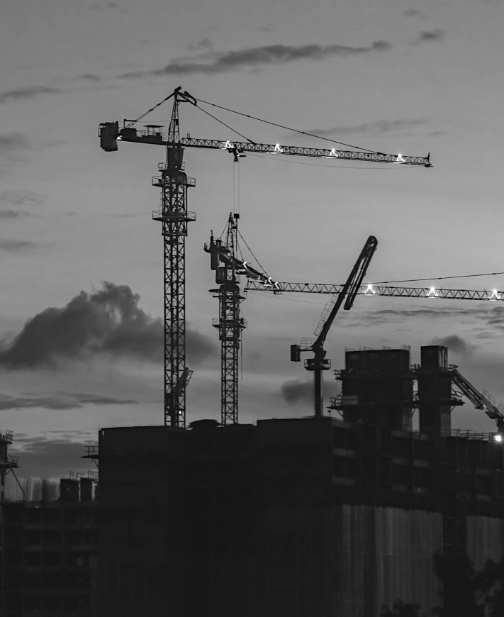 Construction cranes, representing funding and fair pricing enabled by real estate tokenization and improved liquidity.
