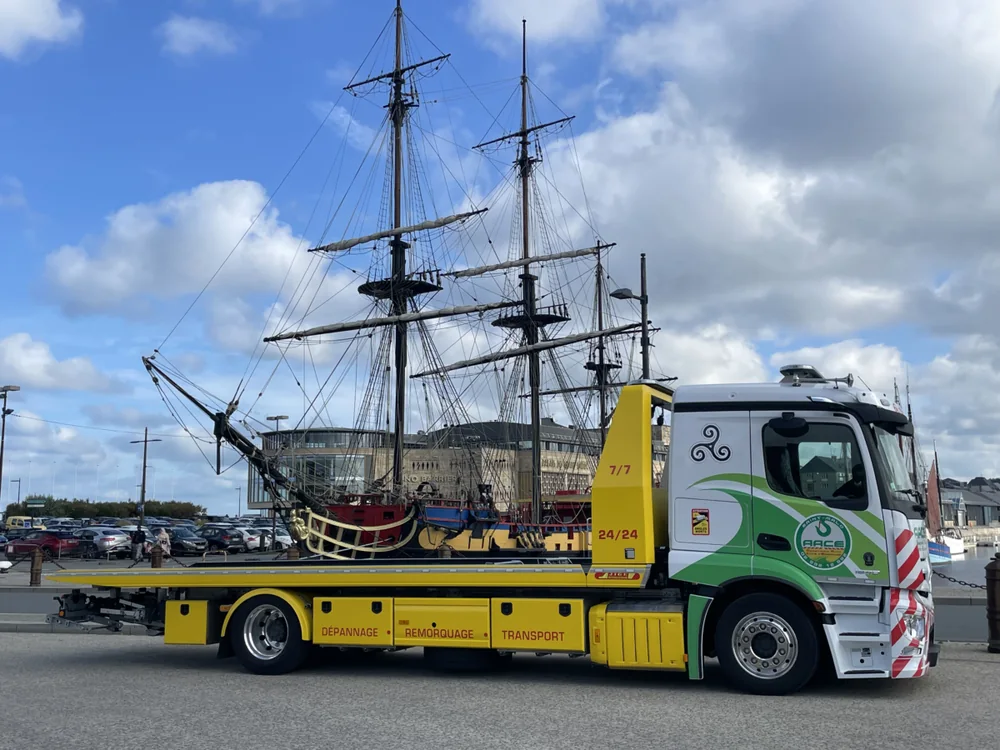 Dépanneuse plateau de la société AACE devant un trois-mâts, sur le port de Saint-Malo