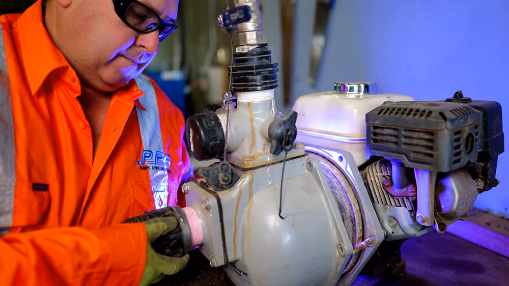 A staff fixing a machine with pipes