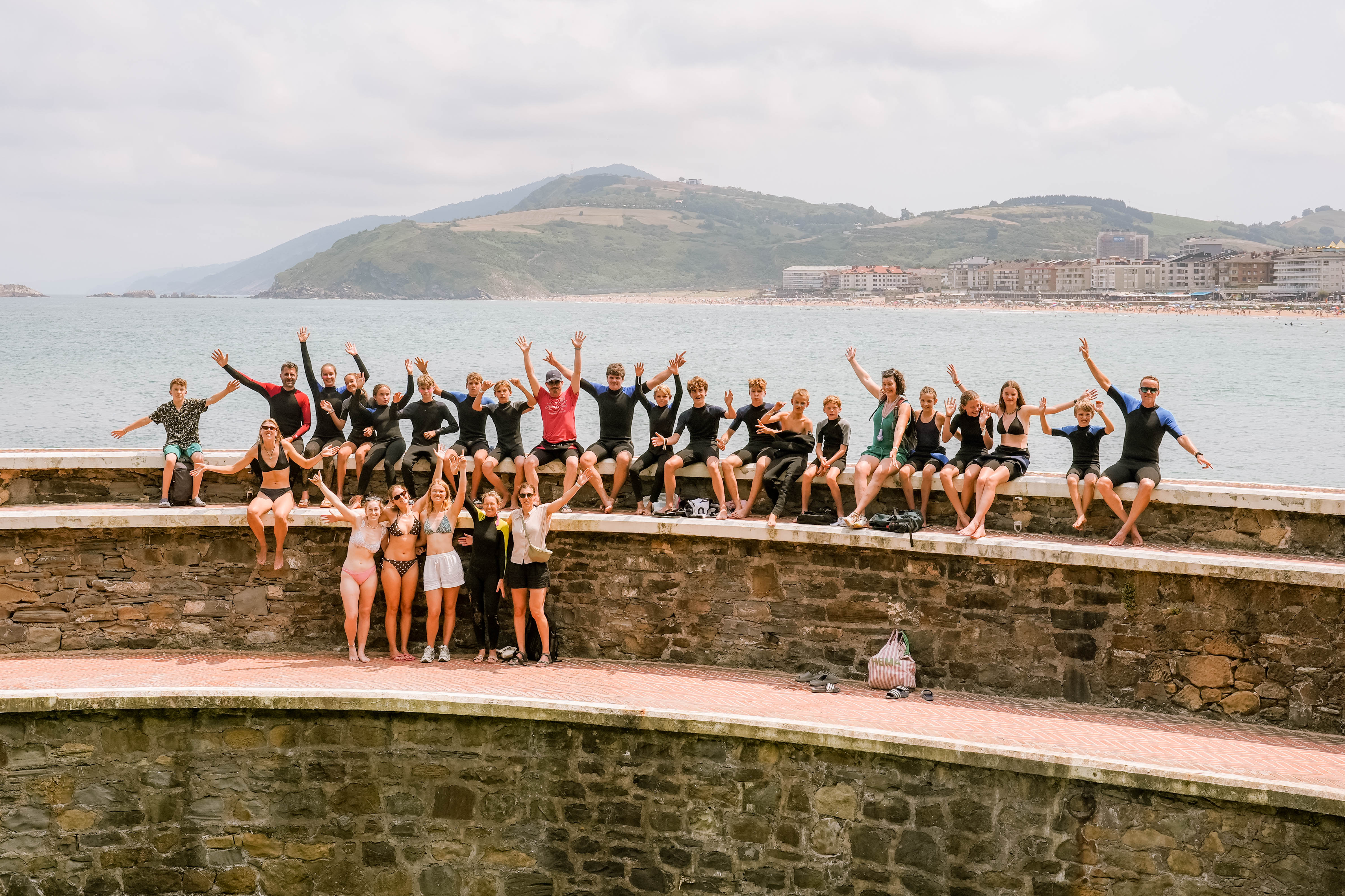 Zarautz family - groepsfoto op de muur bij de zee