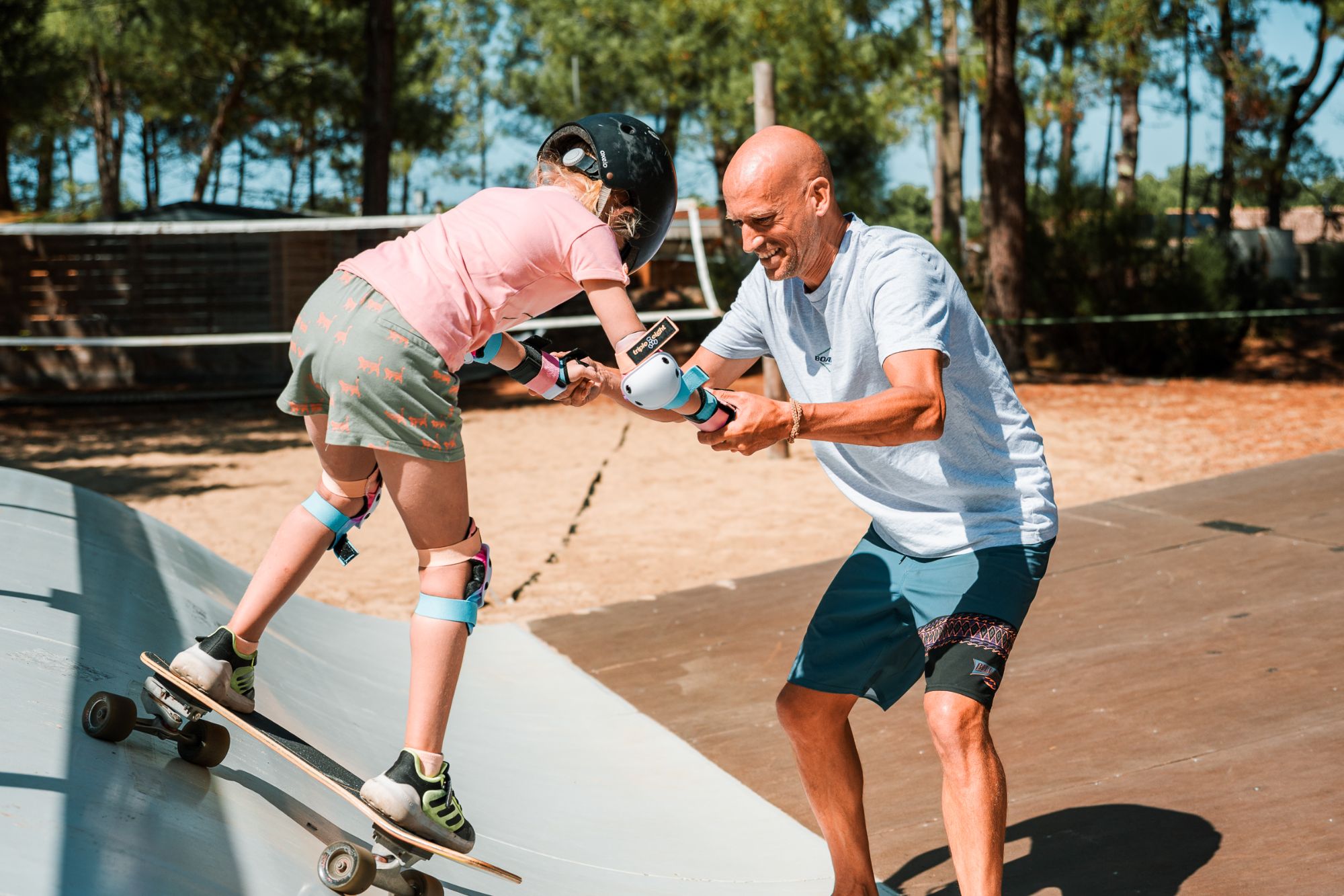 Man helpt kind met skateboarden