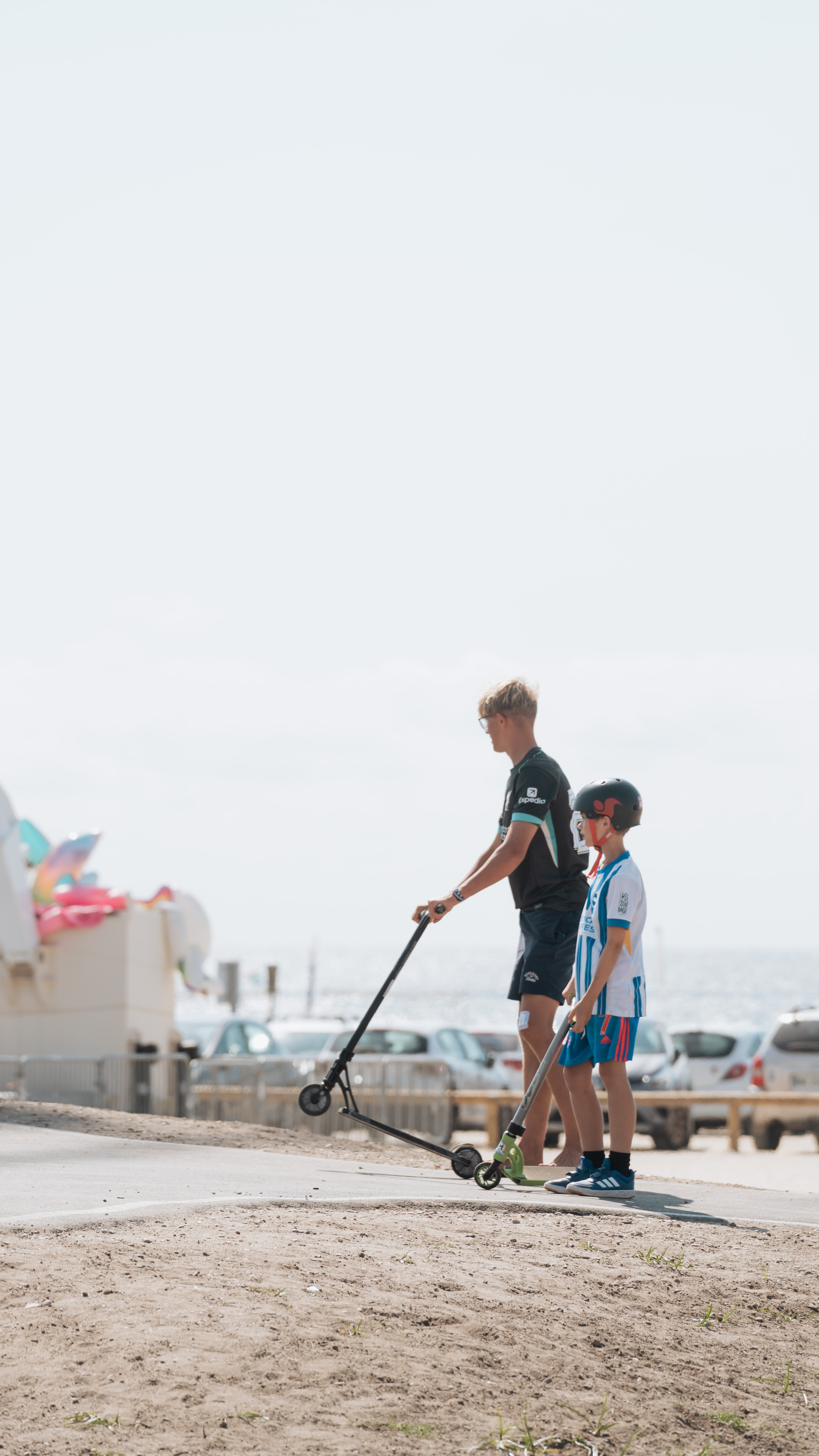 Coach en kind met steps aan zee