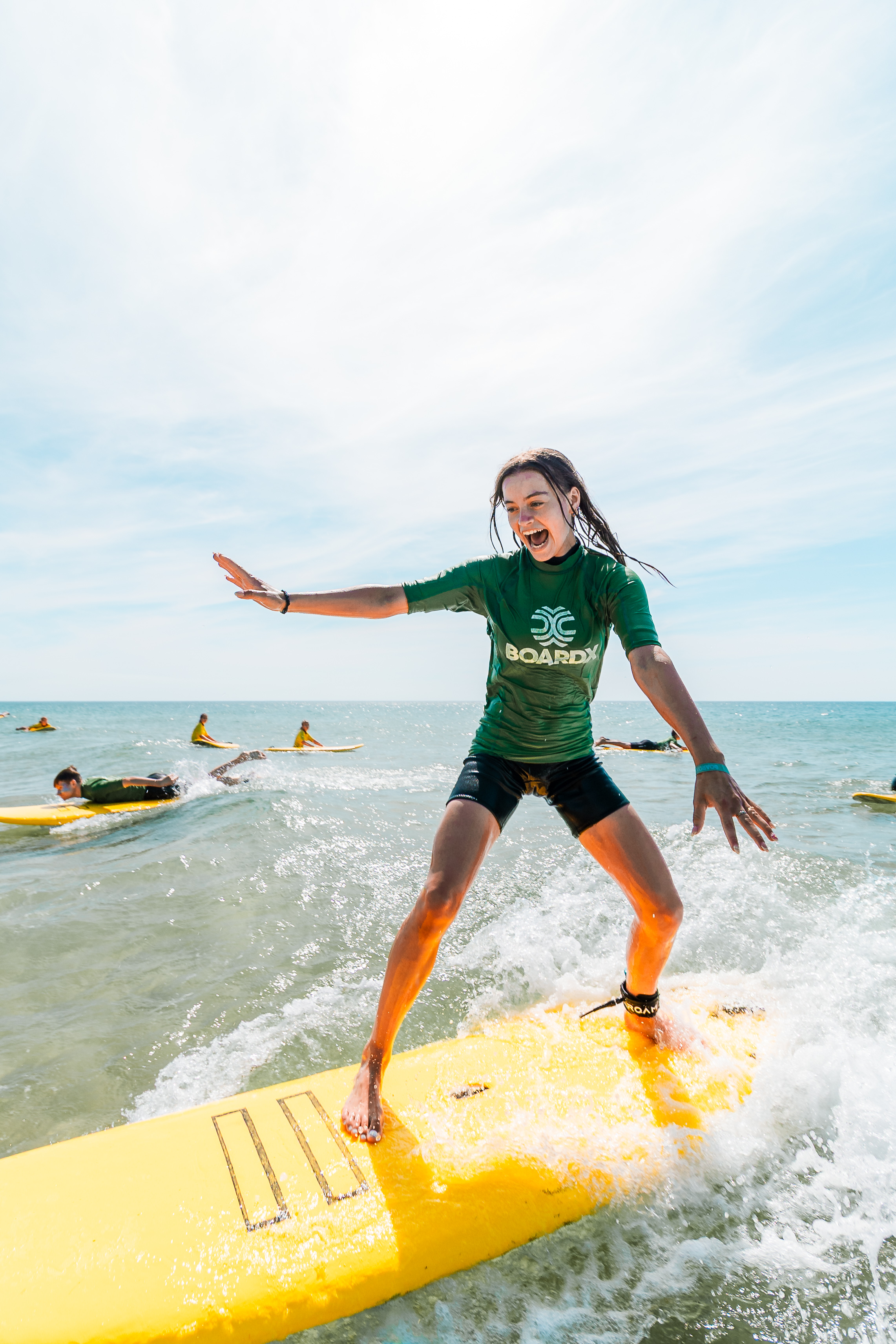 Le Pin Sec surfkamp - meisje surft in groen shirt