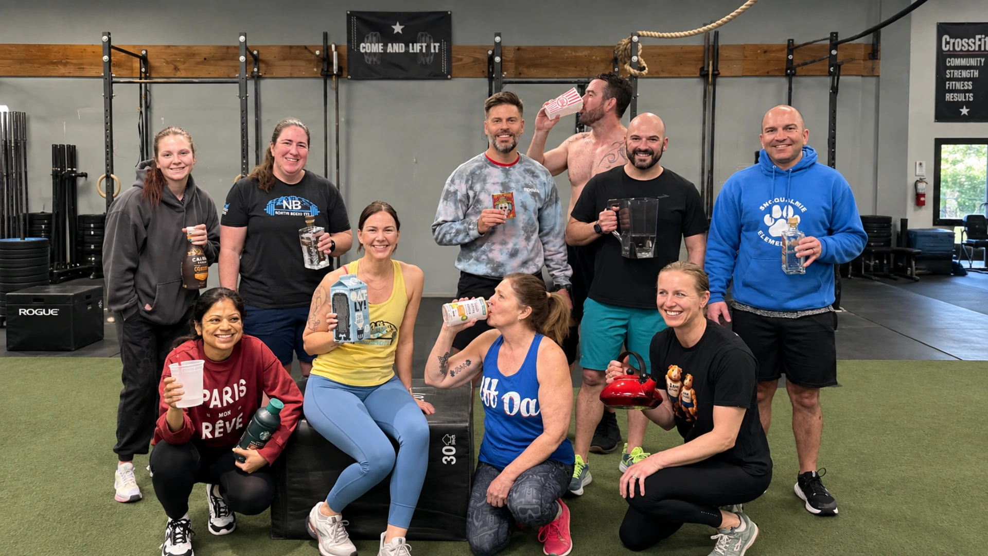 Group of North Bend FIT members celebrating together in the gym, holding drinks