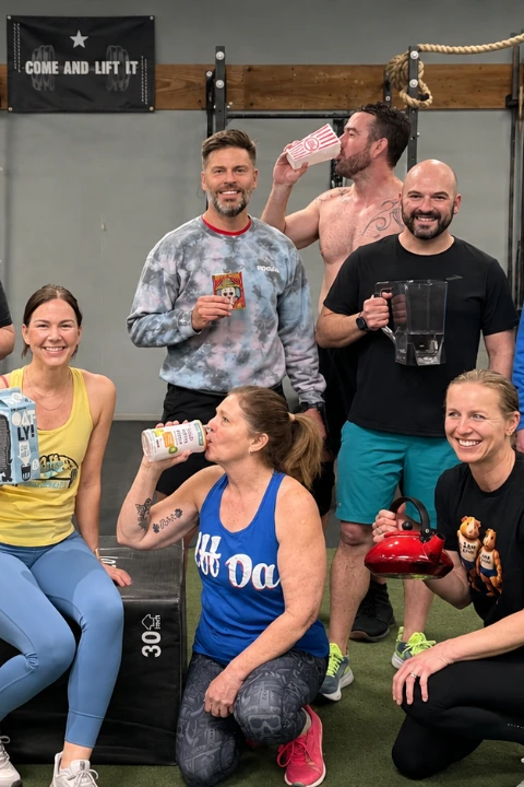 Group of North Bend FIT members celebrating together in the gym, holding drinks