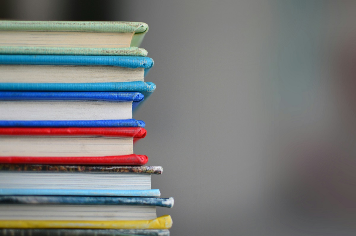 Mehrere bunte Bücher liegen auf einem Stapel. 