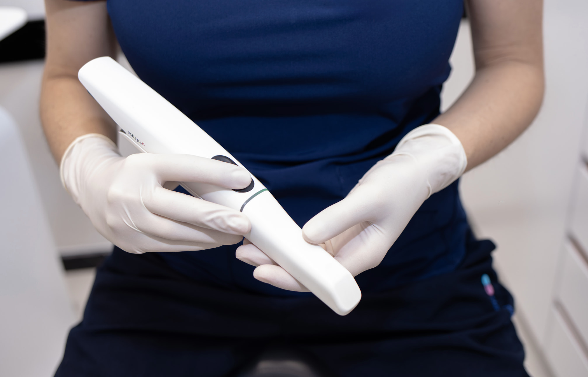 Dentiste scannant une empreinte numérique avec affichage 3D.