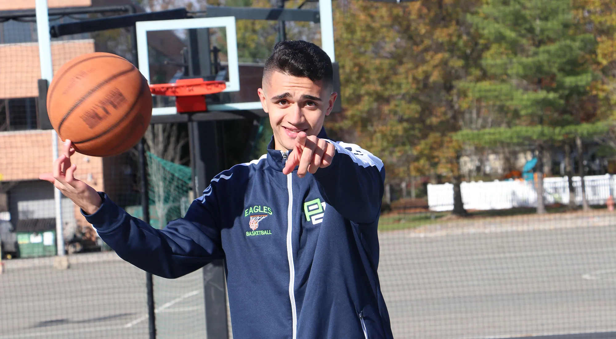 A Pioneer Academy high school students holding basketball in the basketball field