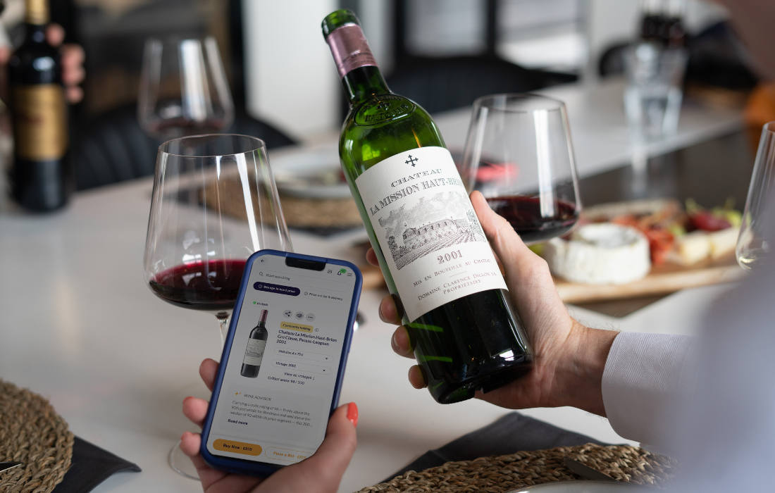 Fine wine collector using the CultX app while holding a bottle of wine