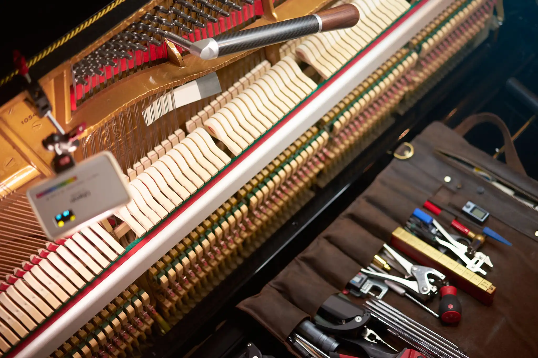 Werkzeuge des Klavierstimmers auf der Klaviatur und offene Mechanik beim Stimmen