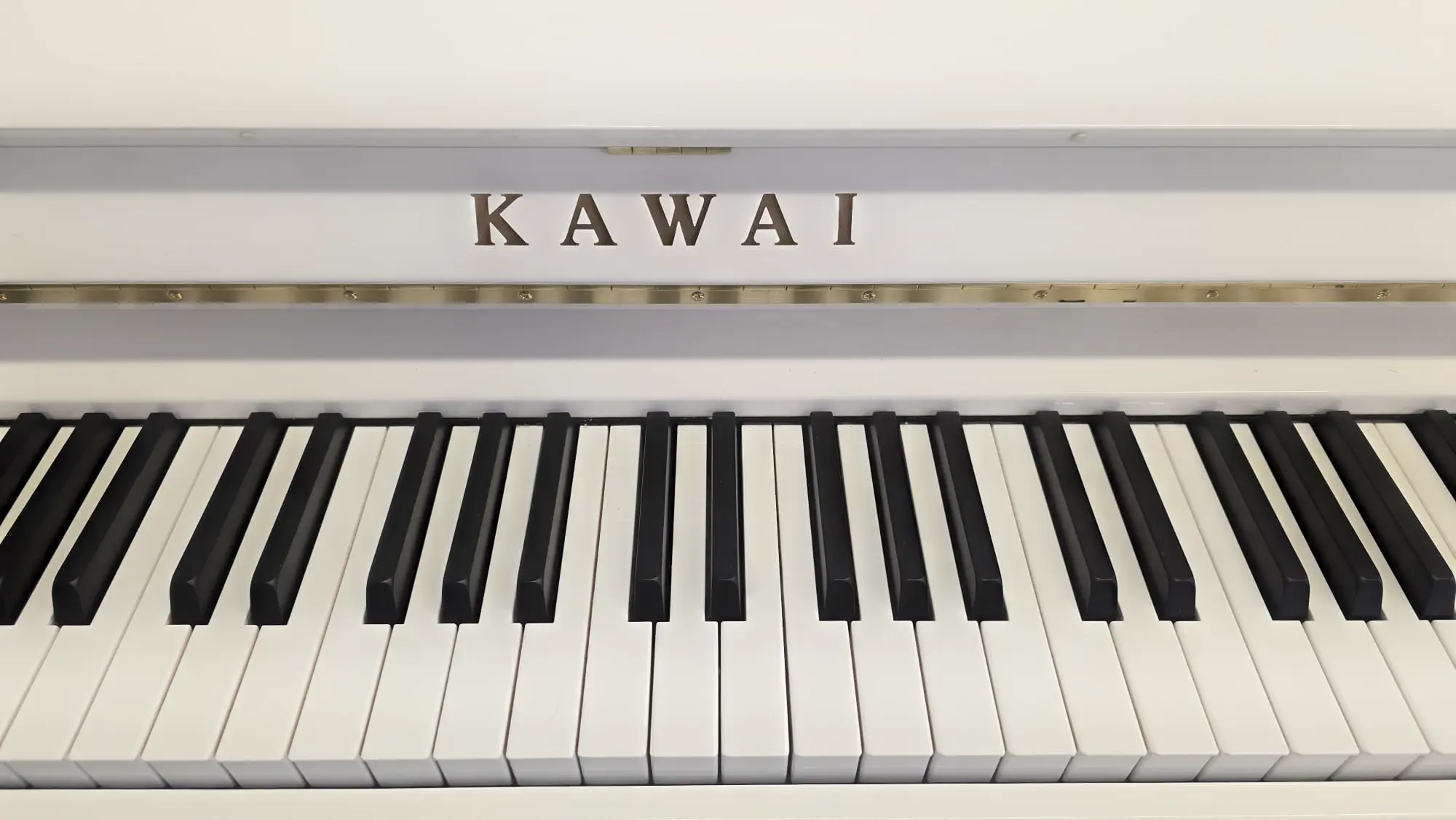 Logo Schield - Kawai Klavier weiß Hochglanz (Polyester, 2022) mit Moderator – Gebrauchtes Klavier kaufen in Berlin, Probespielen Berlin-Steglitz