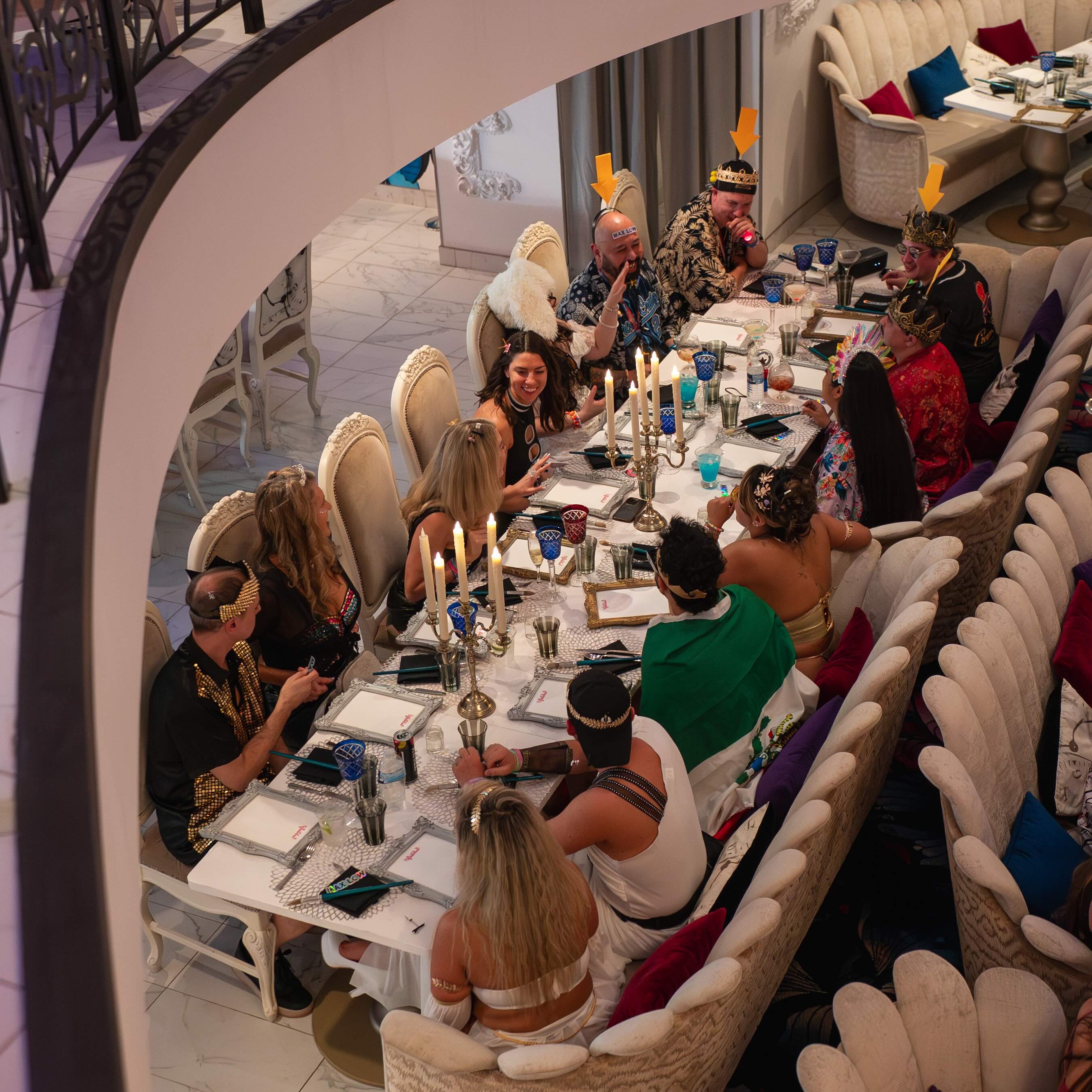  Guests gather around a long restaurant table for a shared celebratory dinner onboard a rave cruise.