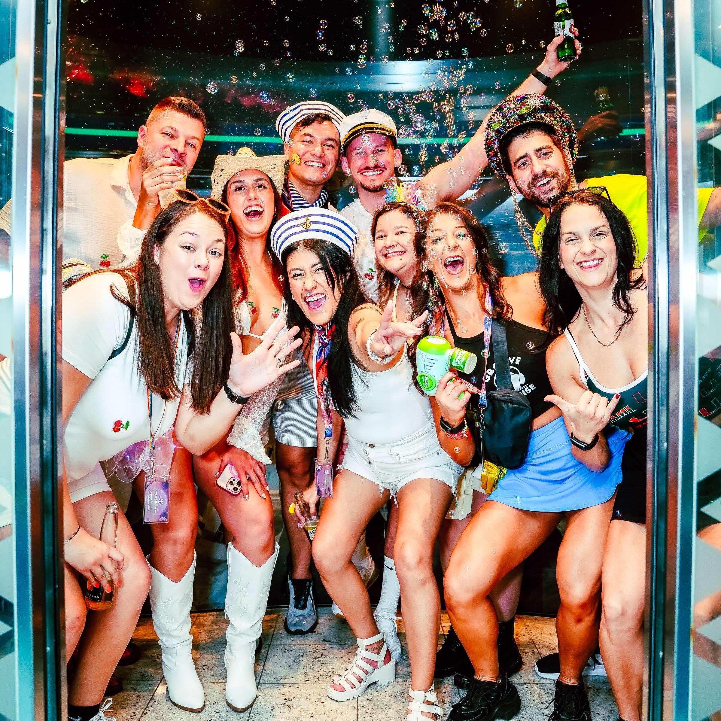 Friends in colorful festival outfits celebrate together on a dance music cruise.