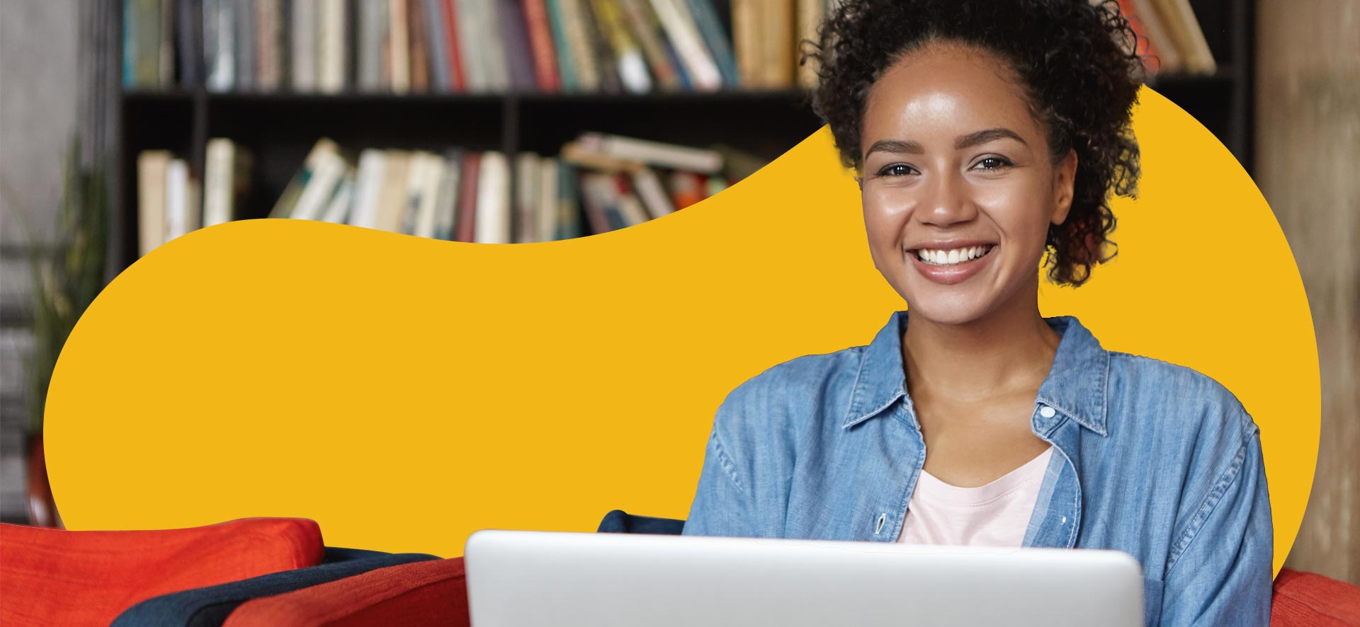 A woman using a laptop against a yellow Designity background.