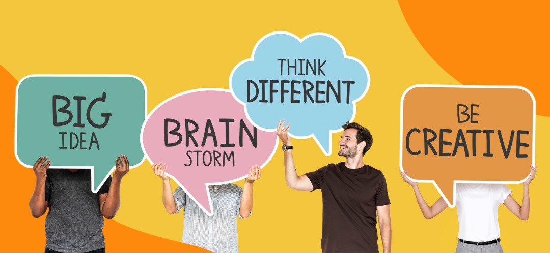 Creatives holding up thought bubble signs. They read, "Big Idea," "Brainstorm," "Think Different," and "Be Creative."