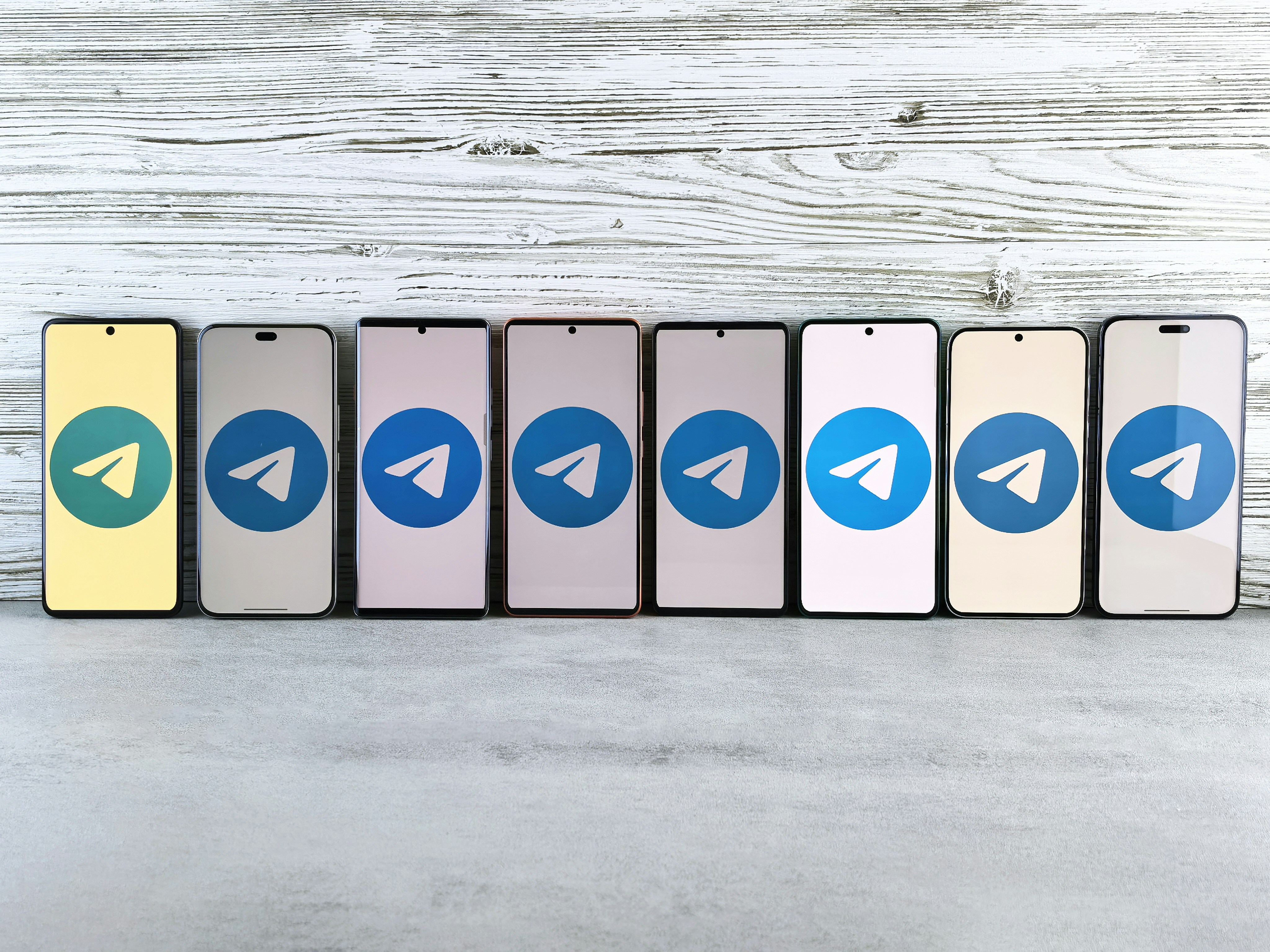 A row of smartphones displaying the Telegram logo, symbolizing the widespread use and potential misuse of the platform for sharing pirated content.